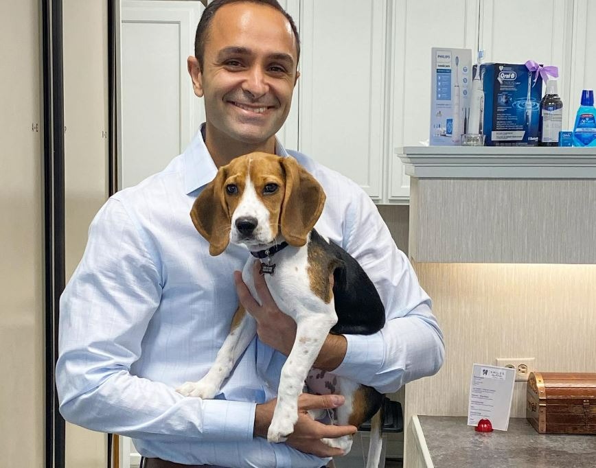 Dr. Edmond Ahdoot holding his dog at the office