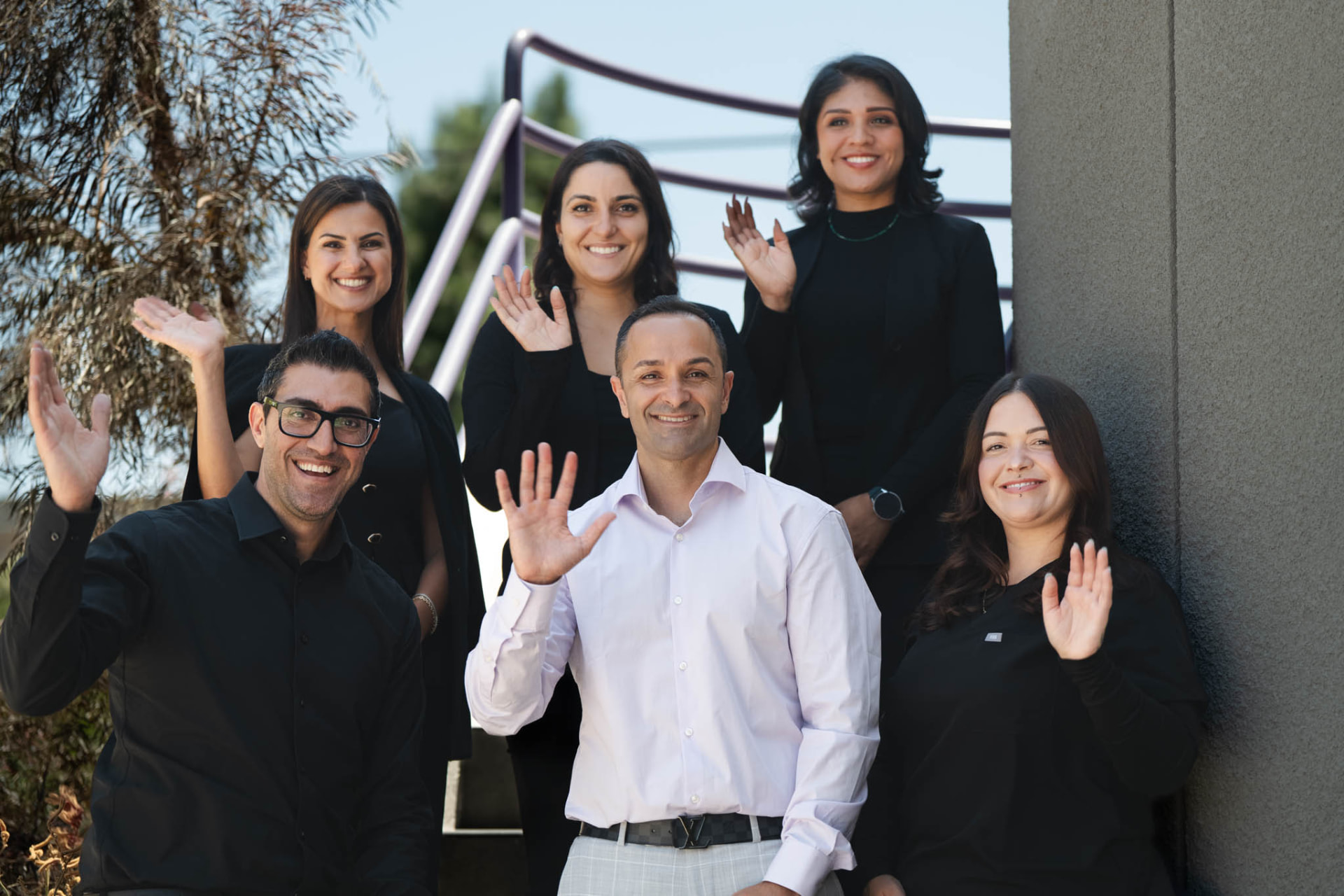 The Smiles by Eddie team waving on the steps outside the office